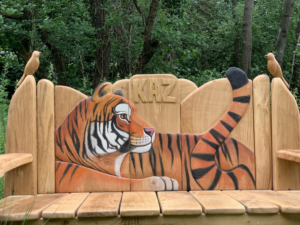 Detailed view of tiger carving on a wooden bench