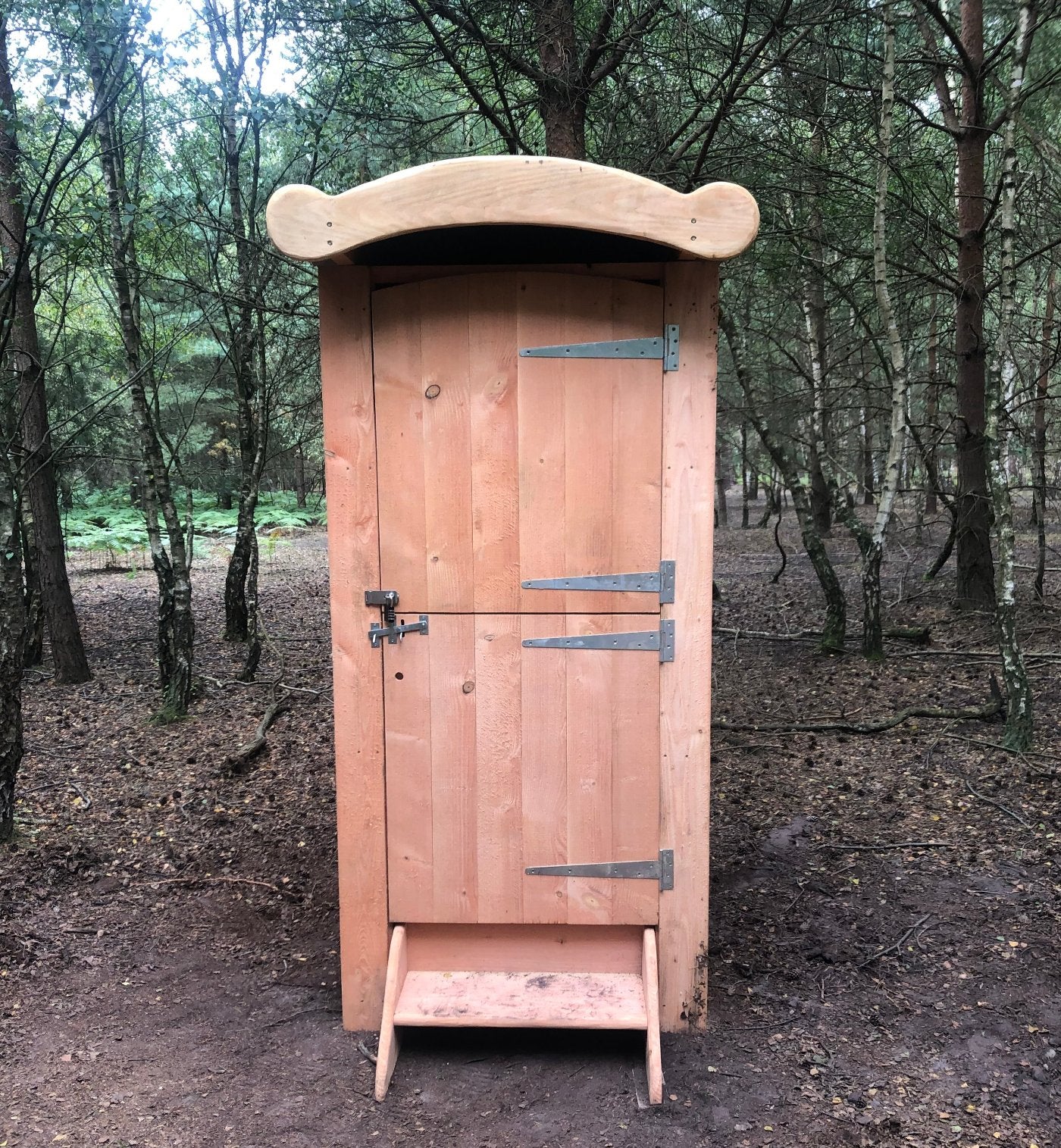 Handcrafted wooden compost toilet designed for woodland community