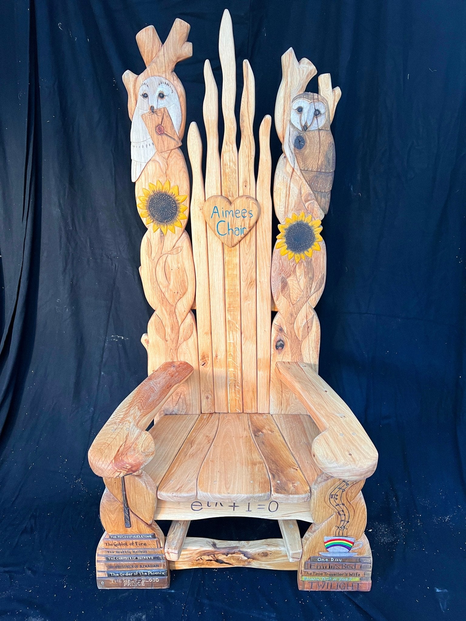 Custom wooden storytelling chair adorned with sunflowers, owls, and engraved Harry Potter titles.
