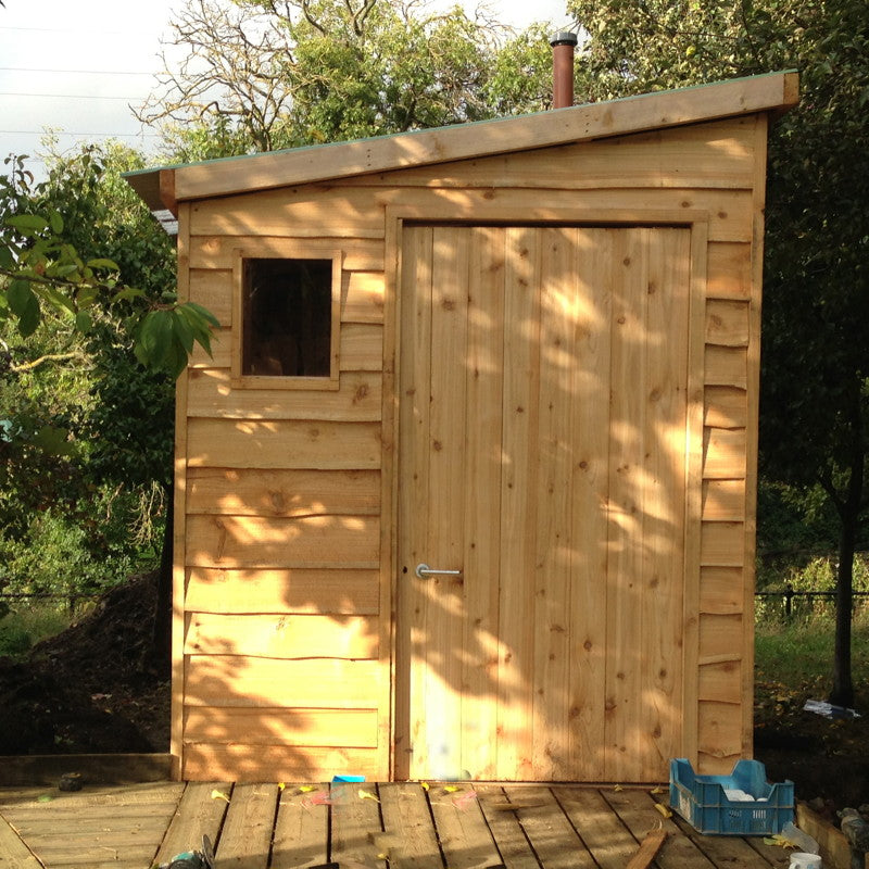 Front view of wooden compost toilet with small window