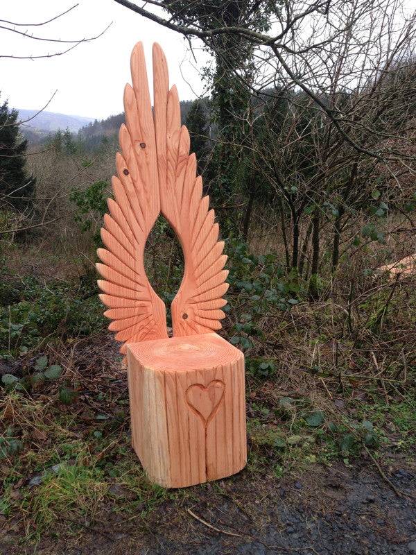 Angel wings carved into oak story chair backrest detail — bespoke handmade fantasy furniture, Wales