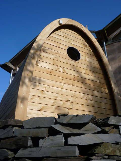 Vue frontale de la toilette à compost Timber Arc avec base en pierre