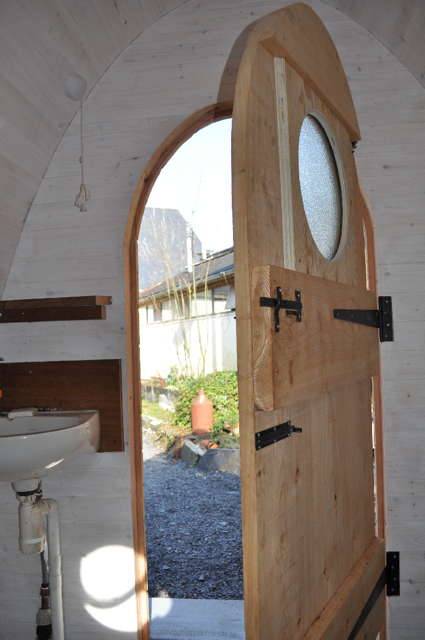 Porte ouverte des toilettes à compostage Timber Arc montrant l'intérieur