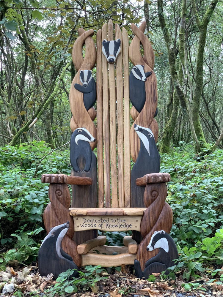 Wooden throne with badger carvings in woods