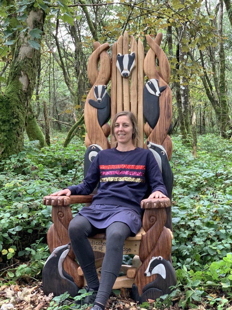 Child seated on carved oak badger storytelling chair — handmade reading throne, Wales