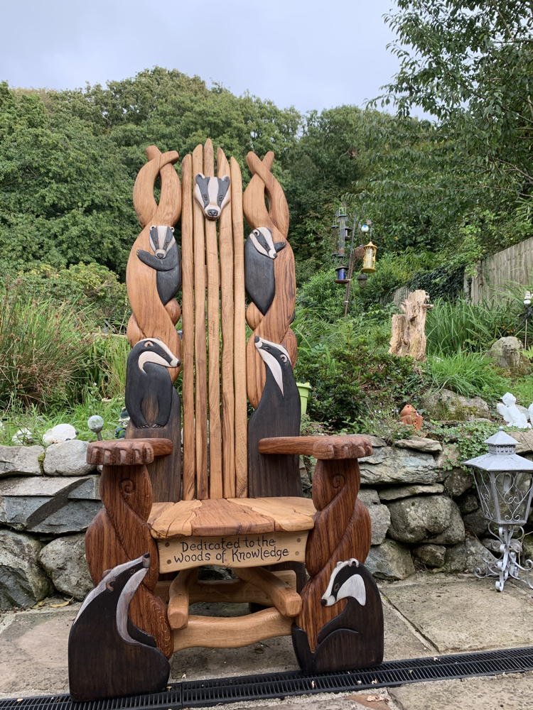 Carved oak badger storytelling chair in garden — handmade reading throne for outdoor schools, Wales