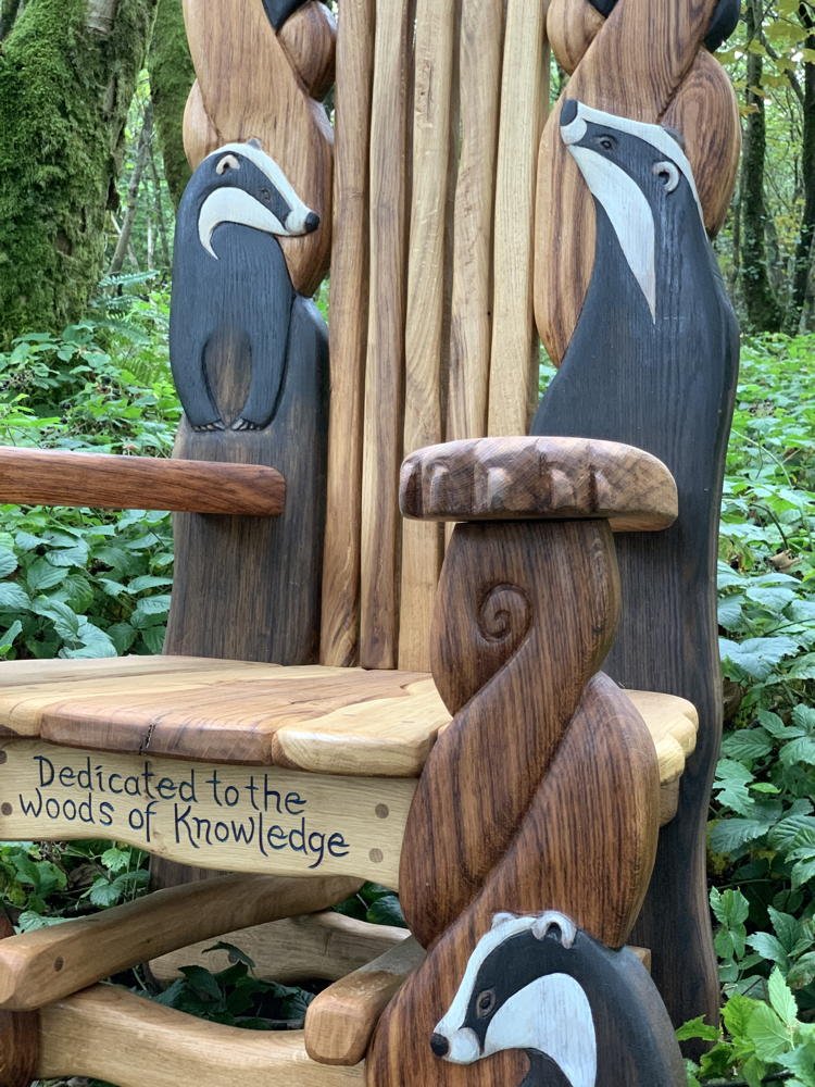 Side view of carved badger details on handmade oak storytelling chair — bespoke wildlife furniture, Wales