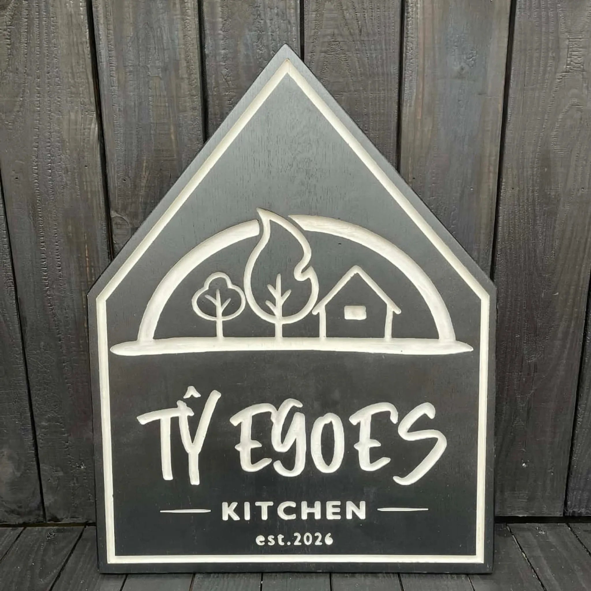 Bespoke house-shaped oak sign with engraved logo, painted charcoal finish — custom wooden signs made in Machynlleth Mid Wales
