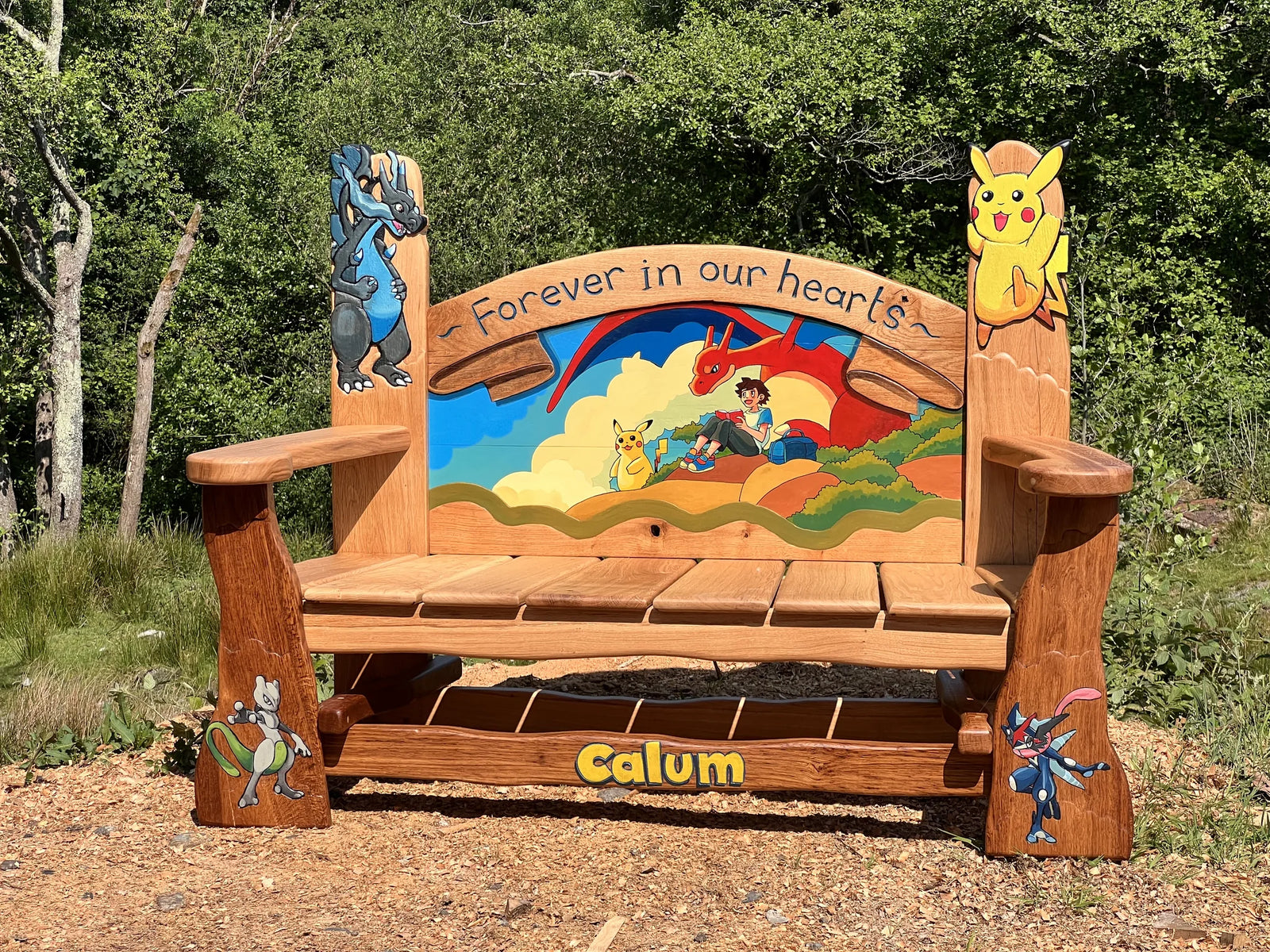 Pokémon memorial bench in solid oak with painted backrest, Pikachu finials and Calum carved into the seat