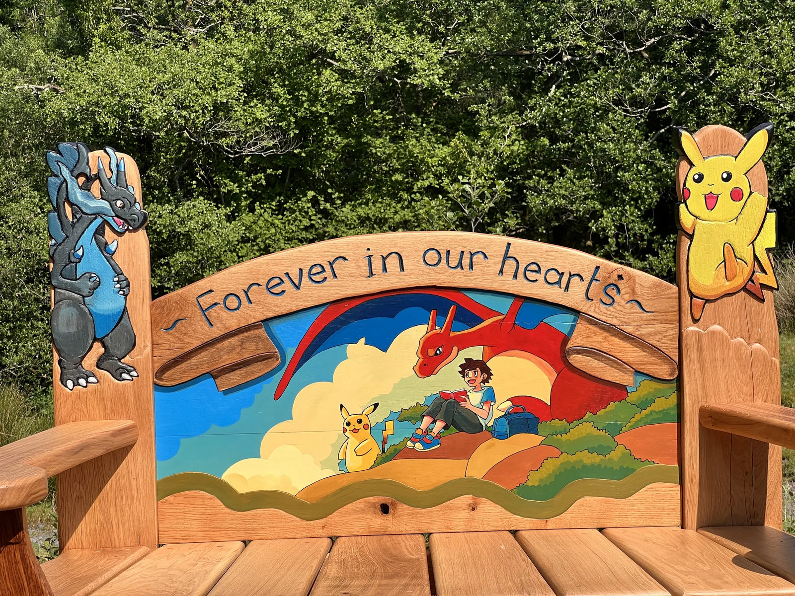Close-up of the painted backrest: a boy reading with Pikachu and Charizard and Forever in our hearts