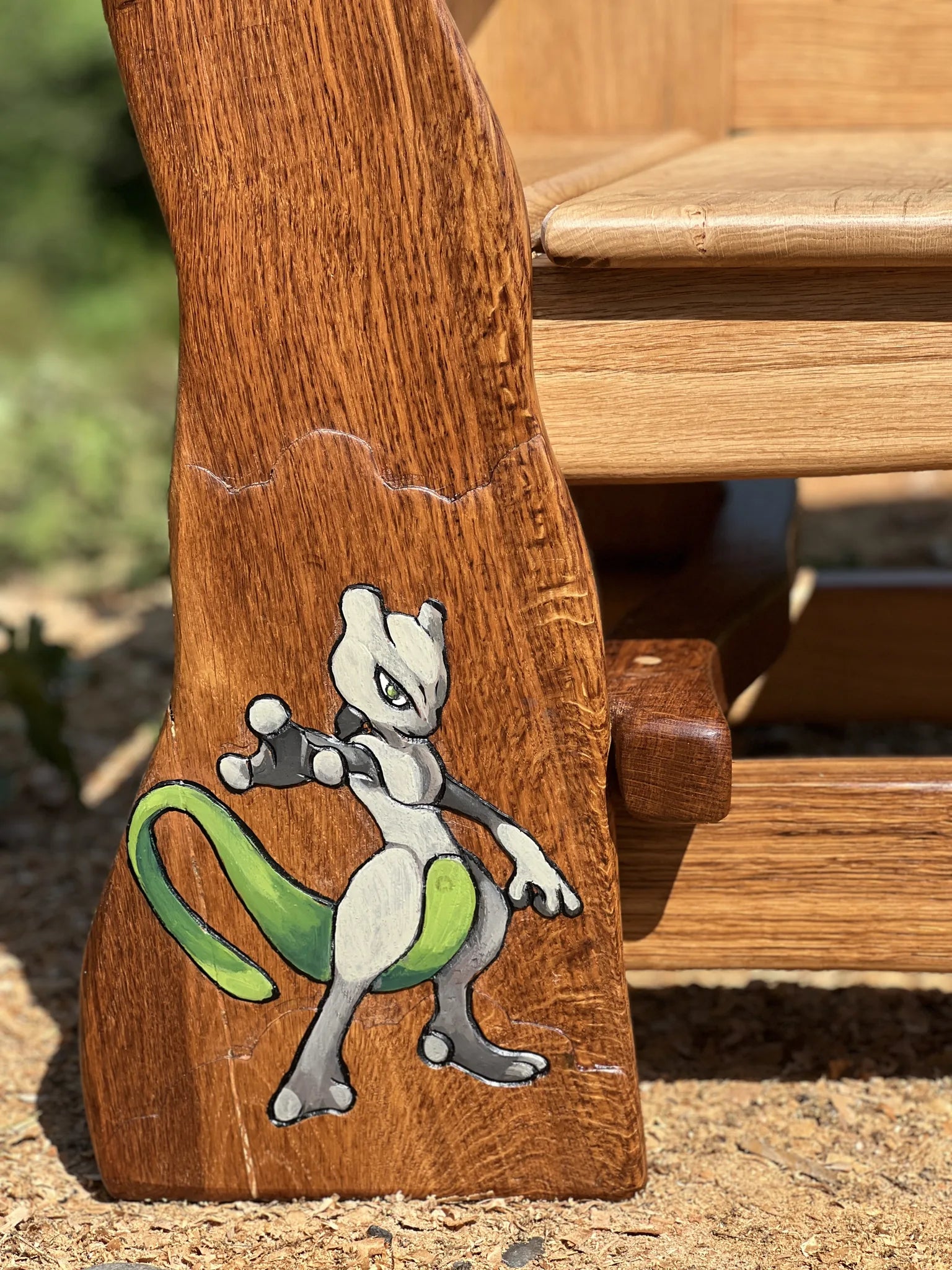 Hand-carved and painted Pokémon character on the leg of the oak memorial bench