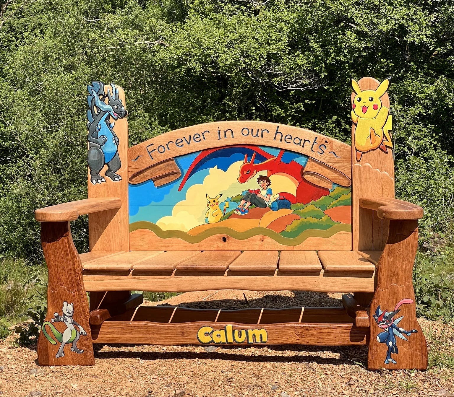 Painted Pokémon backrest scene viewed from above on the hand-carved oak bench