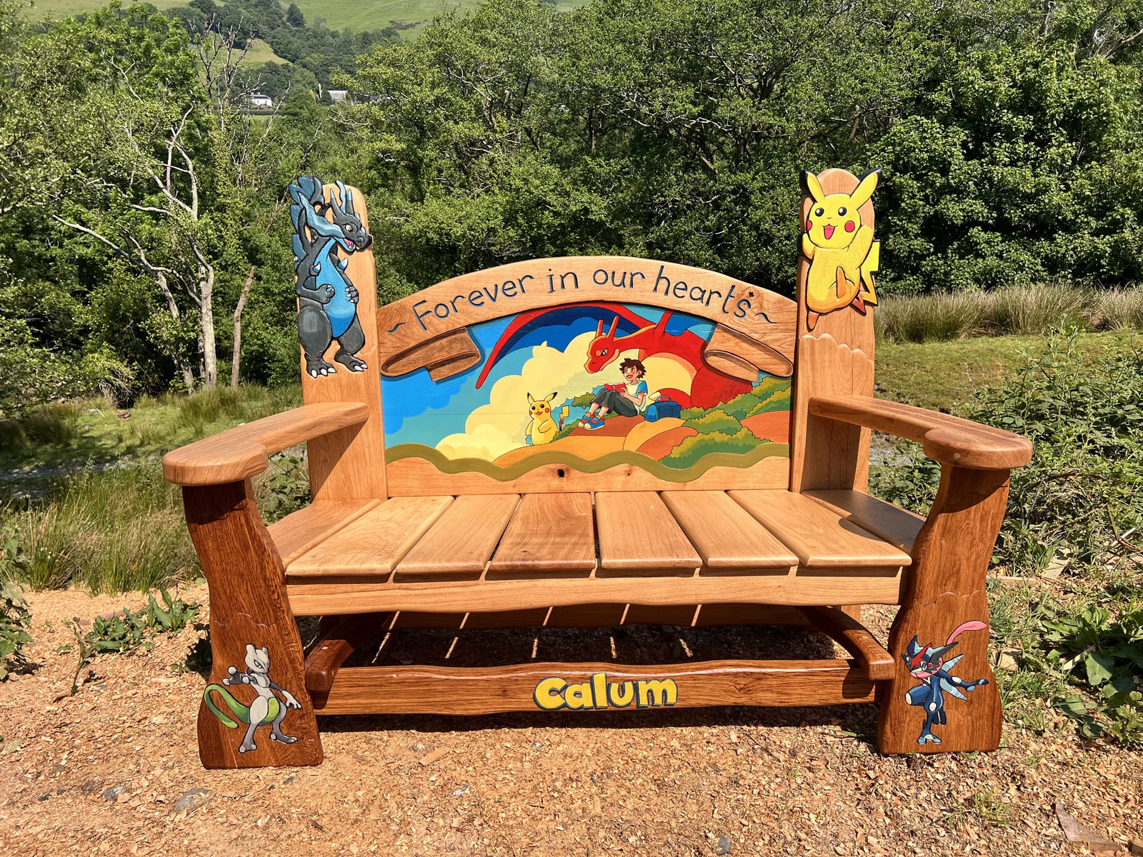 Pokémon memorial bench outdoors, hand-carved from solid oak with bright painted detailing
