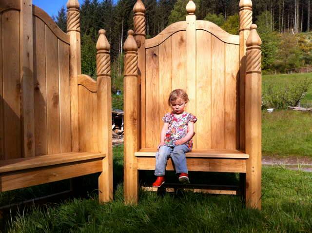 Enfant assis sur une chaise de conte dans un espace herbeux