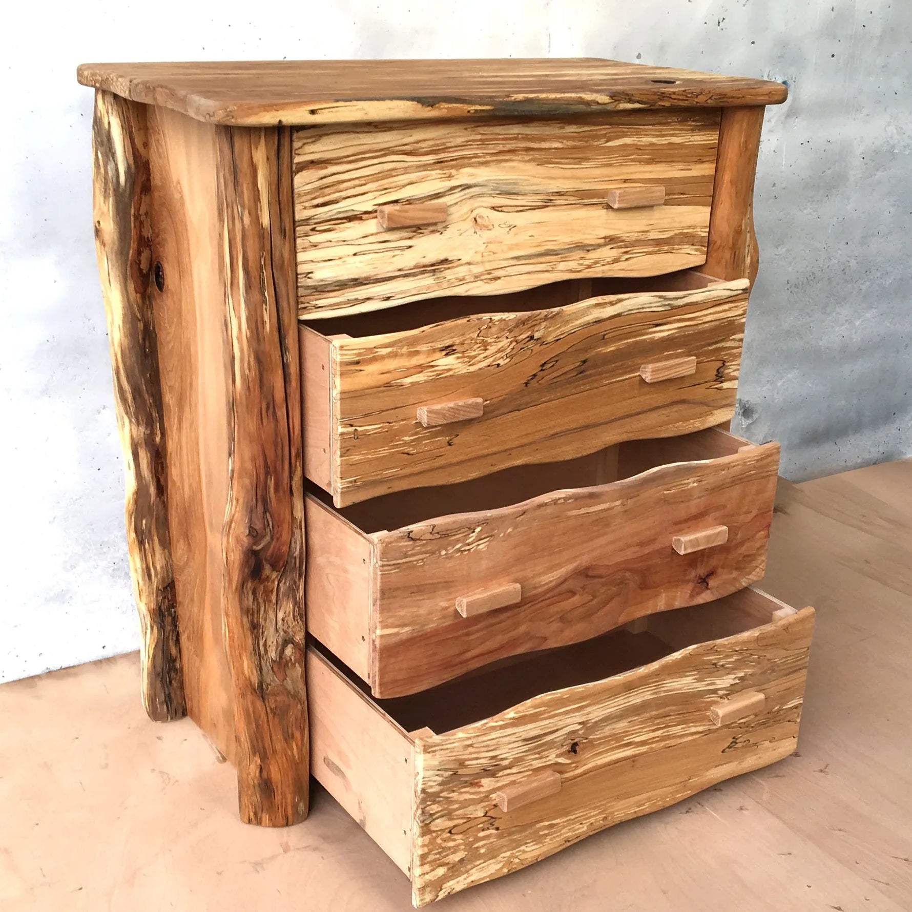 Rustic spalted beech chest of drawers at an angle with drawers open, natural live-edge timber and wooden handles