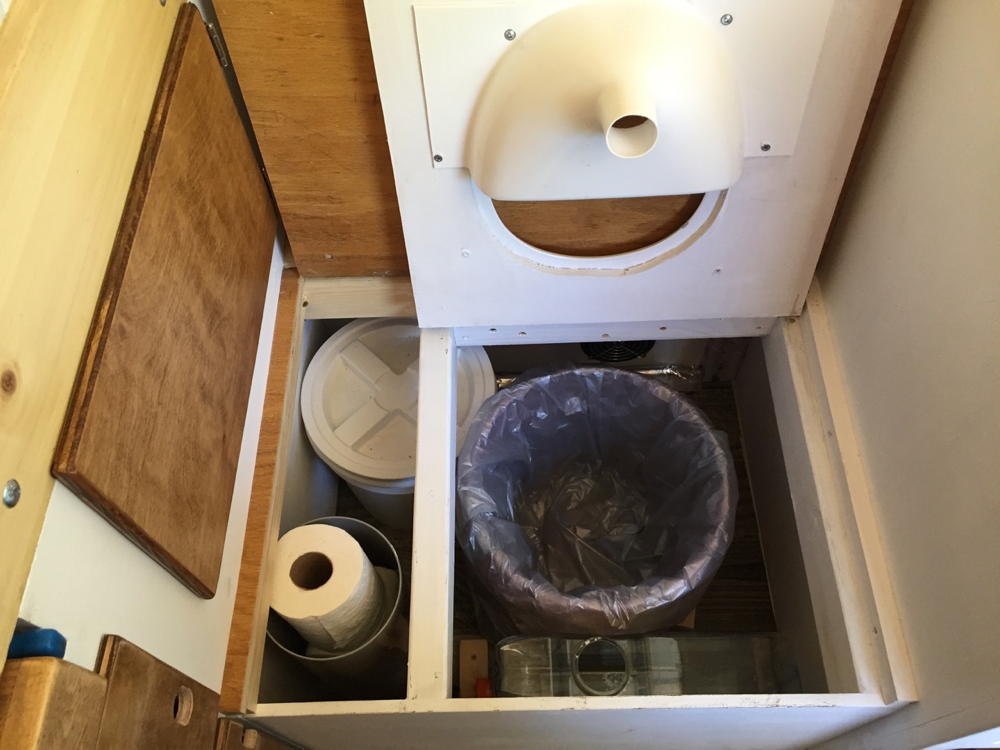 Vue intérieure d'une toilette à compost avec séparateur d'urine installé.