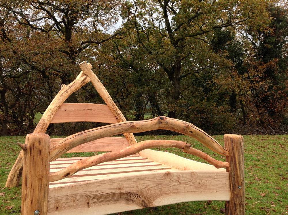 Handcrafted oak cruck frame bed detail — natural wood construction, bespoke furniture Wales