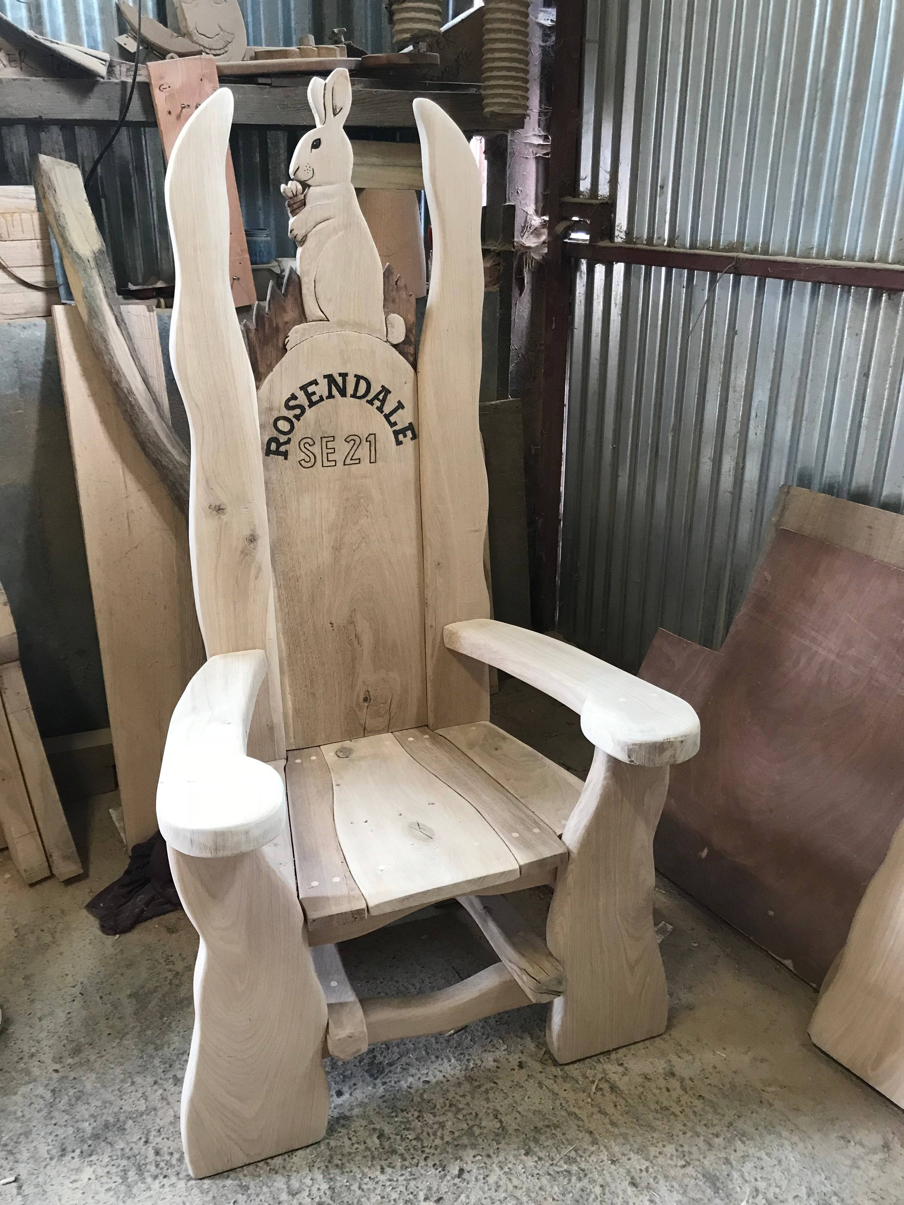 Chaise en chêne avec sculpture de lapin dans un atelier