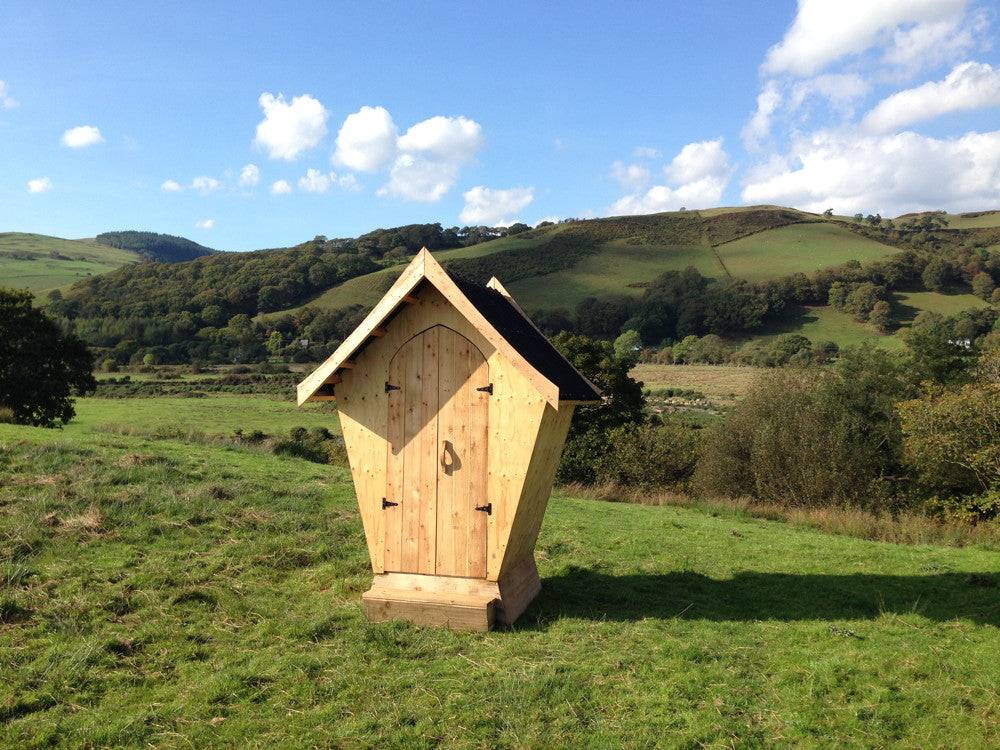 Handmade designer compost toilet outdoors — stylish eco-friendly wooden facility, Wales