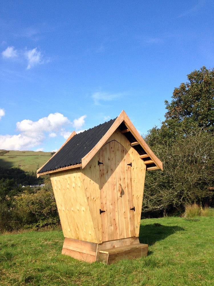 Designer composting toilet in field setting — handcrafted wooden eco outdoor facility, Wales