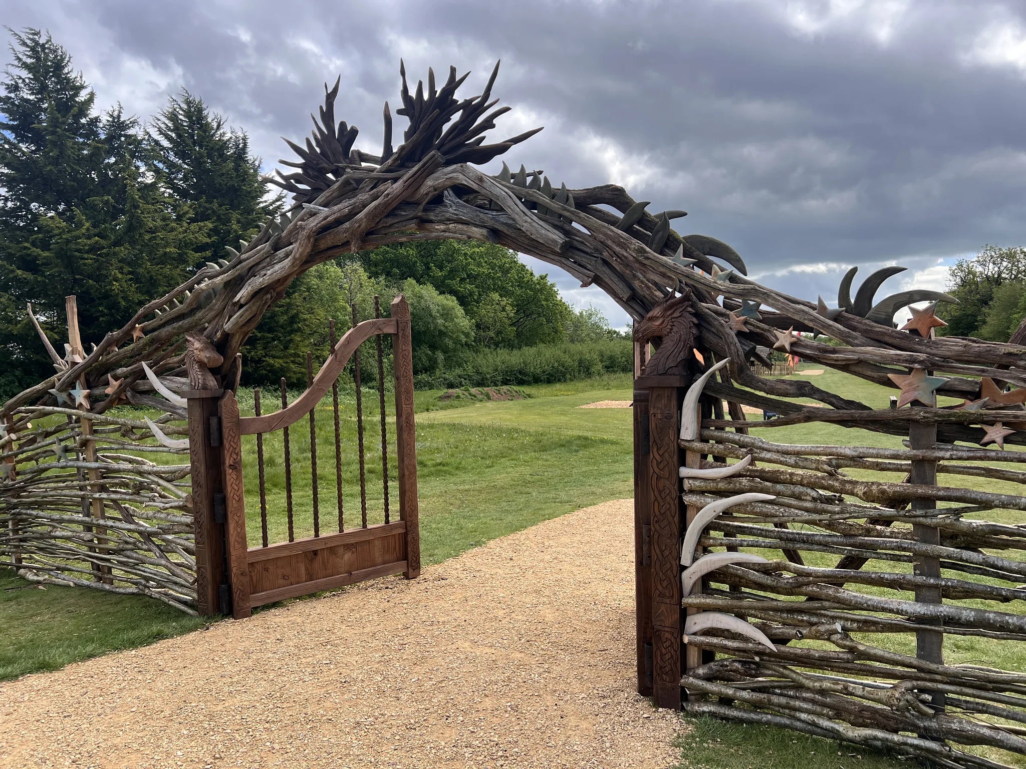 Dragon Trail archway and Celtic gate from outside showing full driftwood structure and hand-carved posts