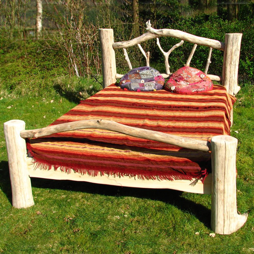 Handcrafted driftwood double bed frame in natural setting — bespoke bedroom furniture, Wales