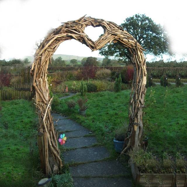 Arche en bois flotté en forme de cœur dans un jardin