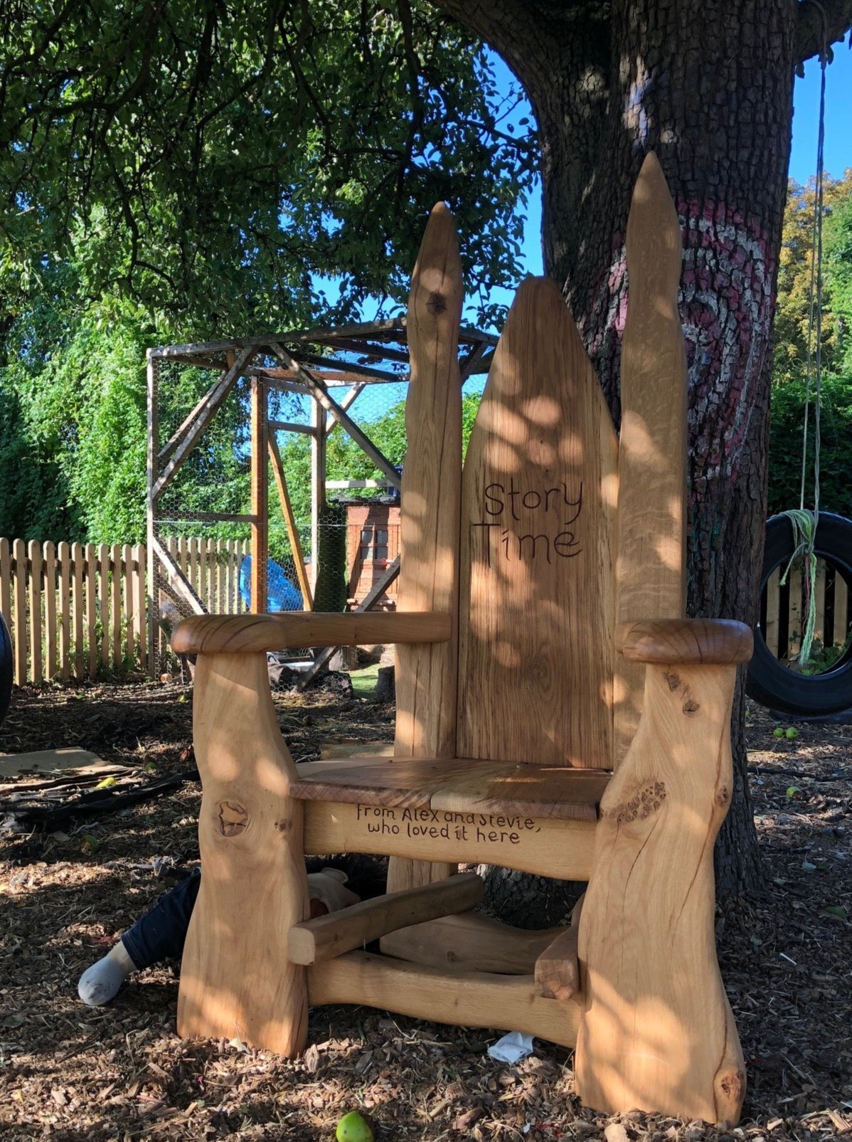 Oak elven story time chairs arranged under a tree in school outdoor learning area — Mid Wales