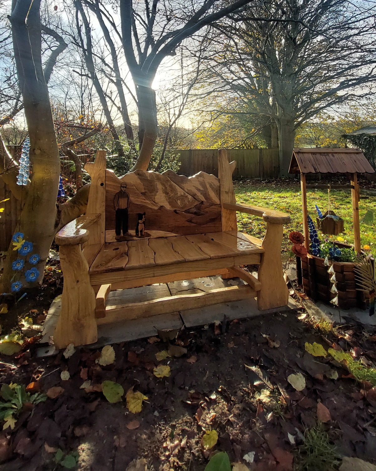 Carved Everest mountain bench in oak, lit by low winter sun in a Kent garden