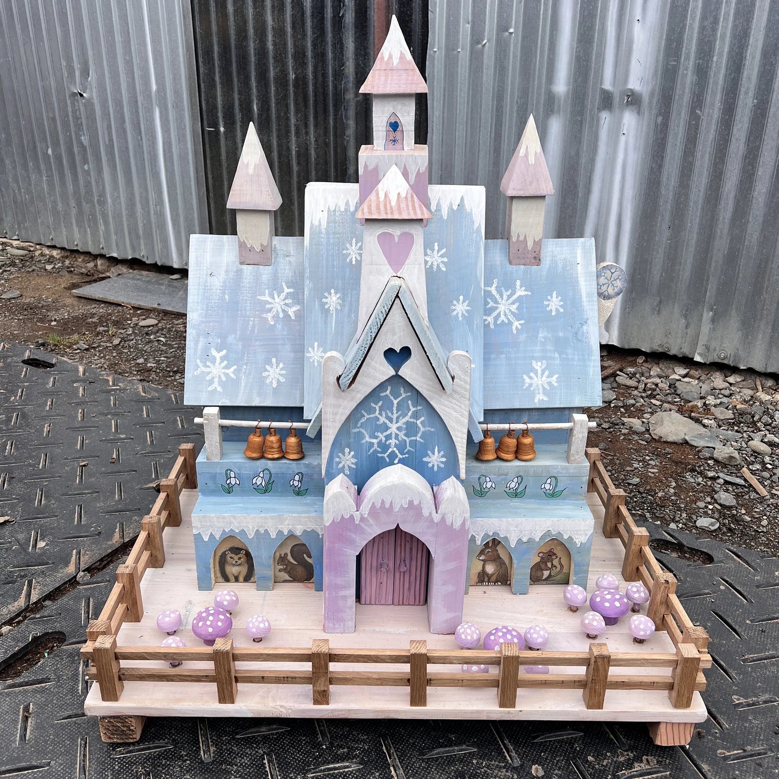 Handmade ice palace fairy house with frosted blue and white paintwork, snow-capped towers and snowflake door details