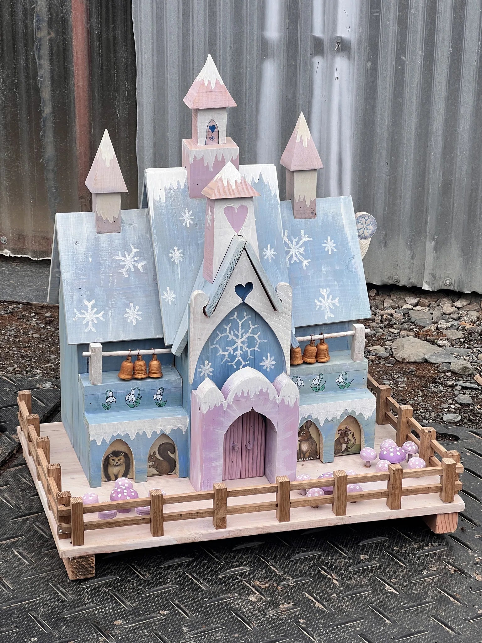 Side view of handmade ice palace fairy house showing pale blue and white paintwork and pointed spires