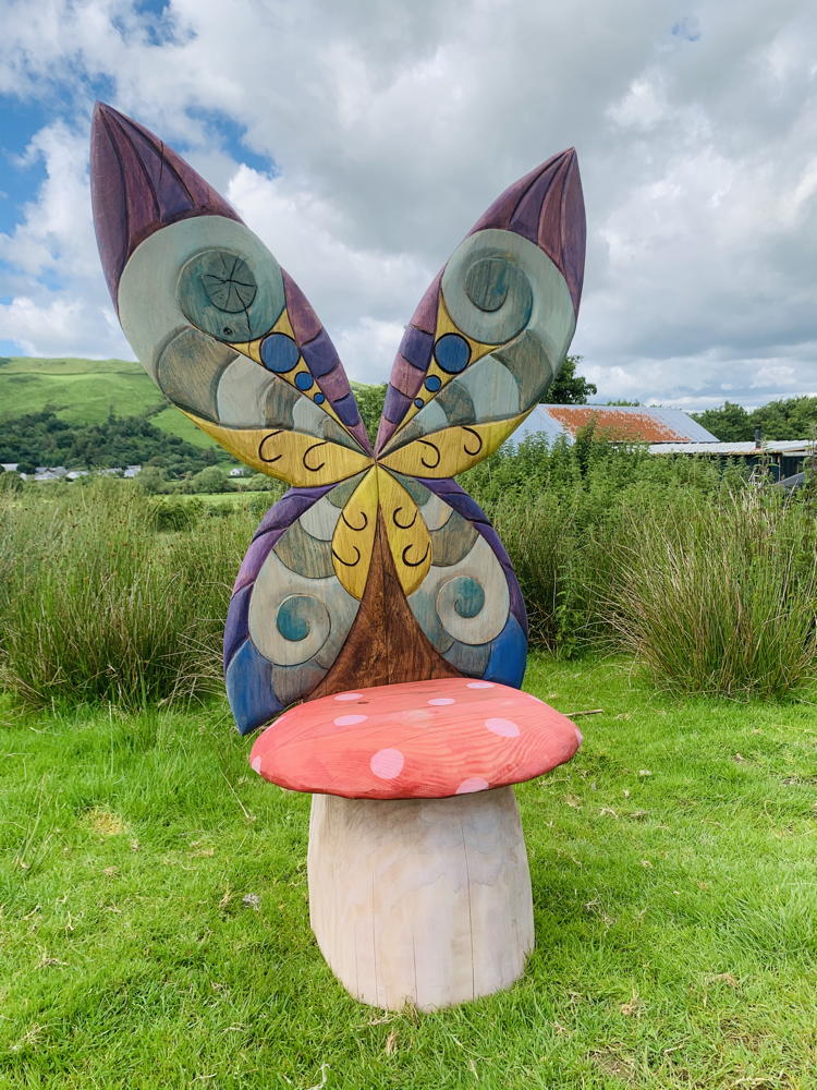 Chaise de fée fantaisiste avec des ailes de papillon dans un espace herbeux