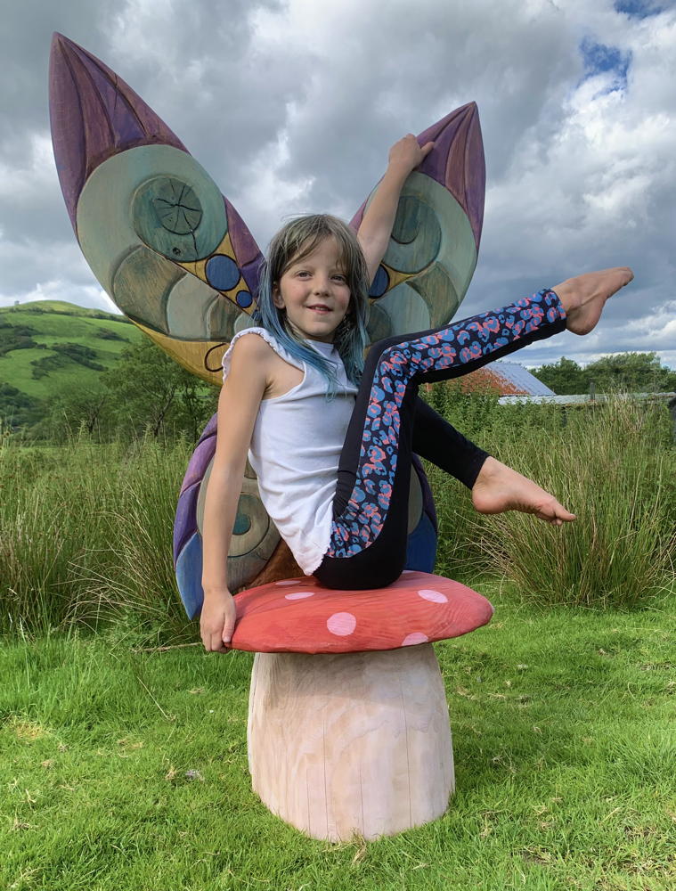 Enfant assis sur une chaise de fée en forme de champignon en plein air