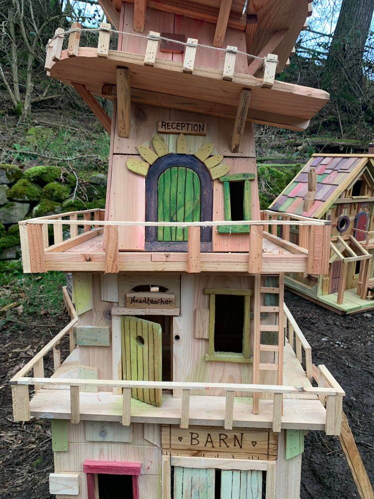 Tall fairy house with multiple levels and barn sign