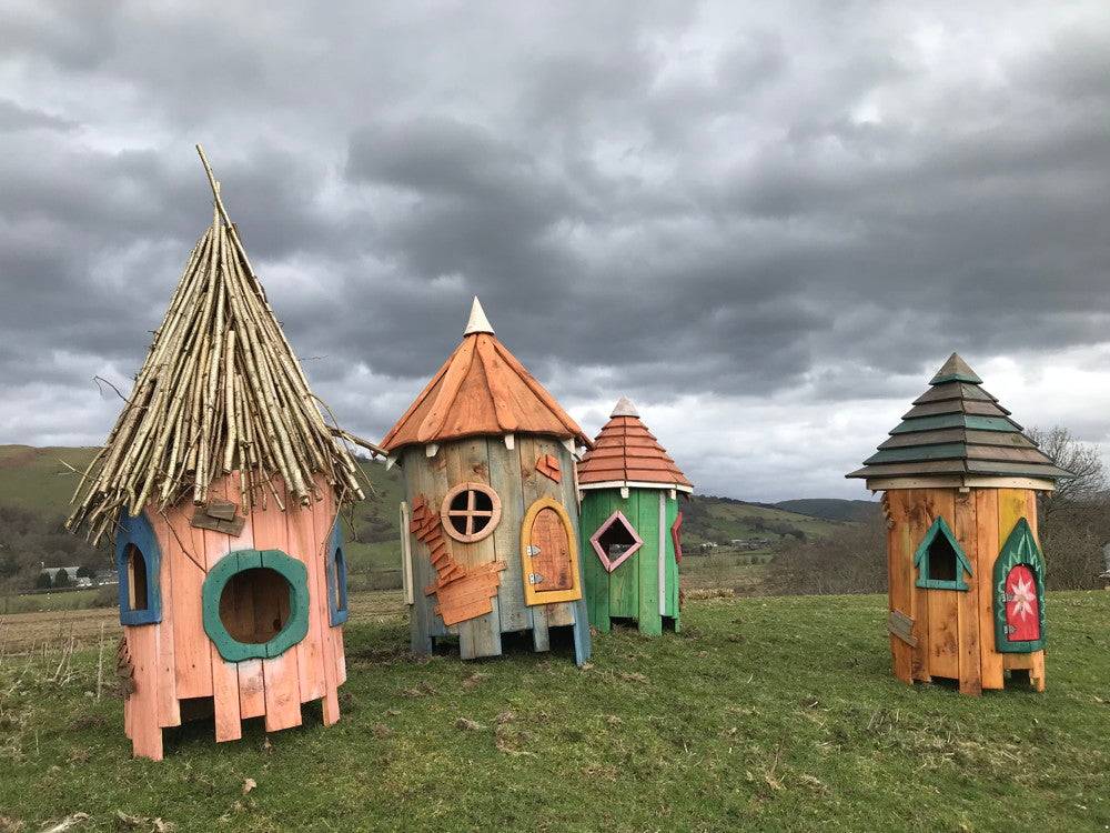 Fairy houses with unique roofs in an open field