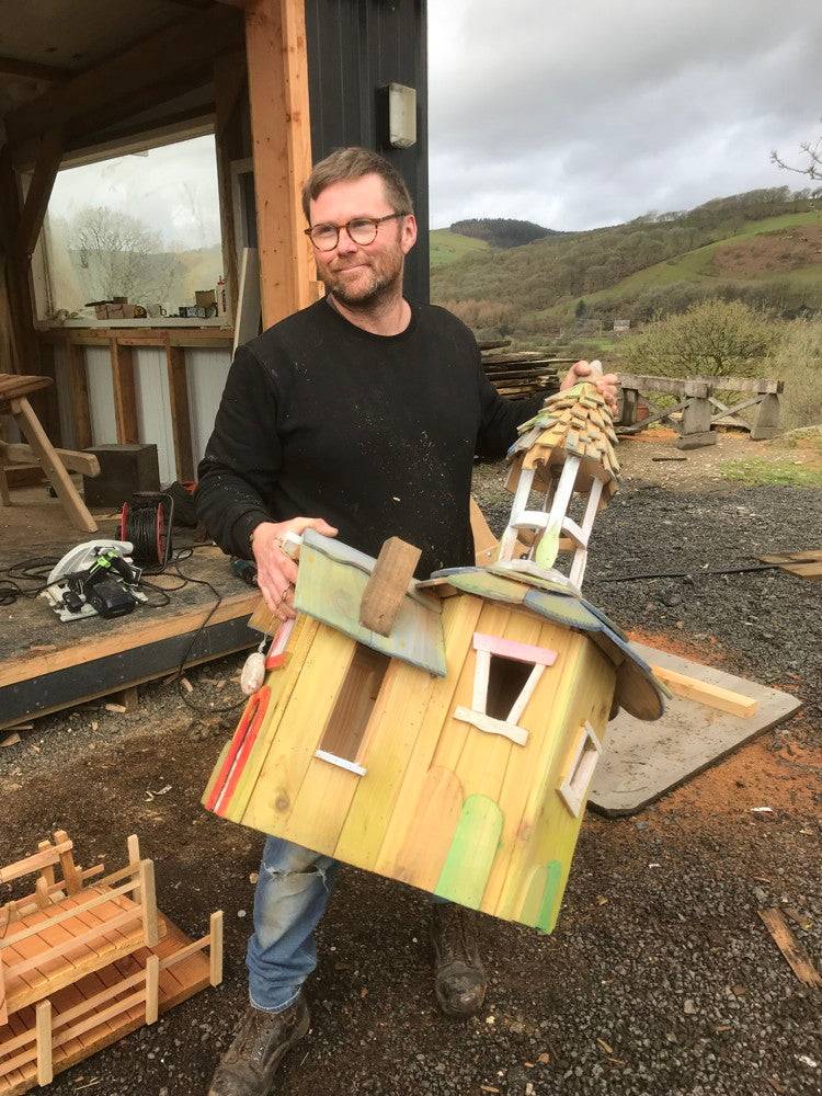 Personne tenant une maquette de maison de fée colorée