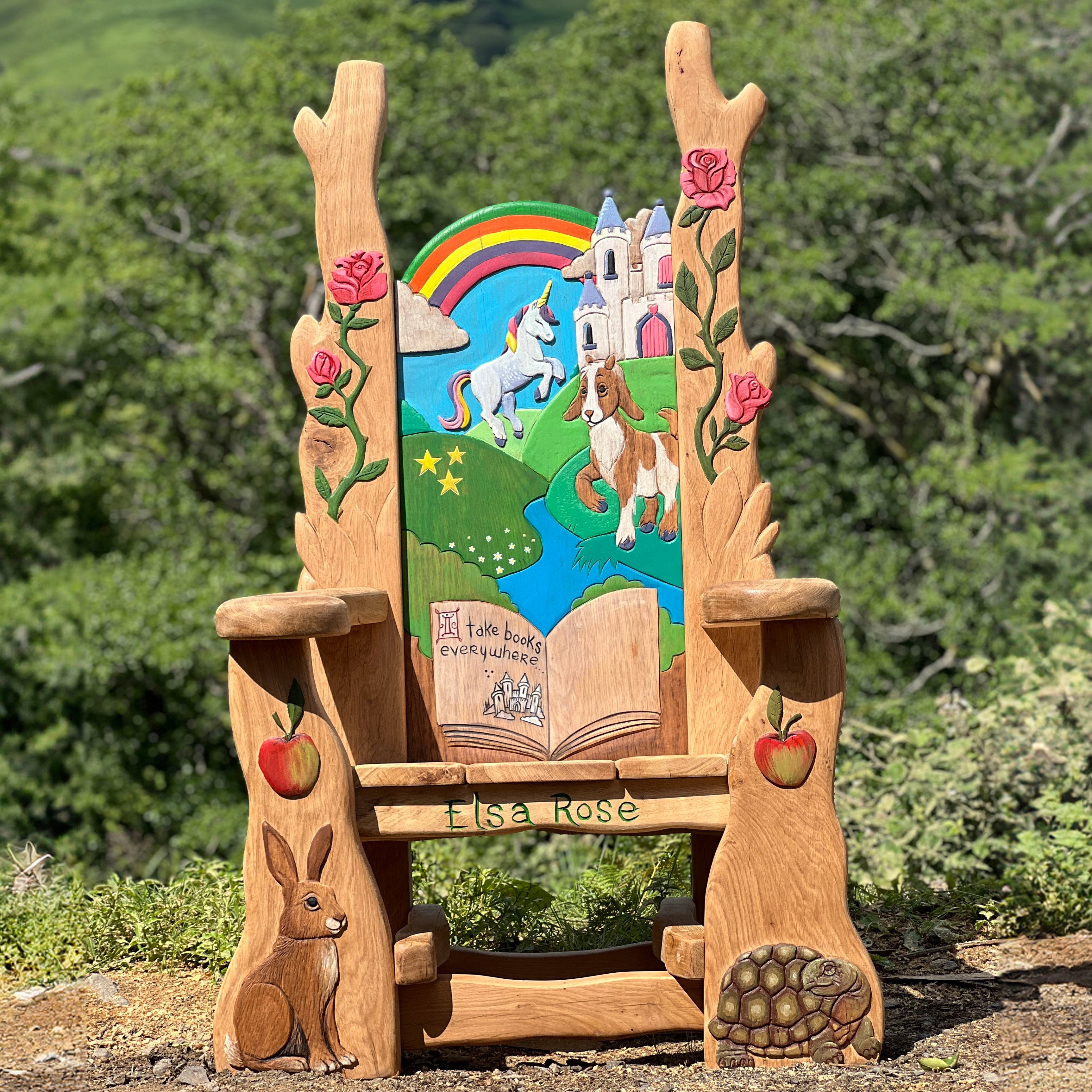 Hand-carved oak storytelling chair with unicorn and dog artwork, personalised with the name Elsa Rose