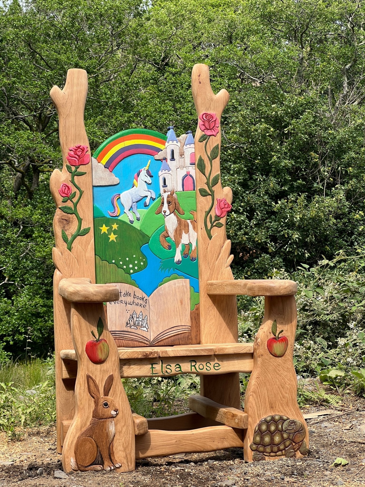 Whimsical wooden storytelling chair featuring a dragon, castle, and frog carved into the backrest