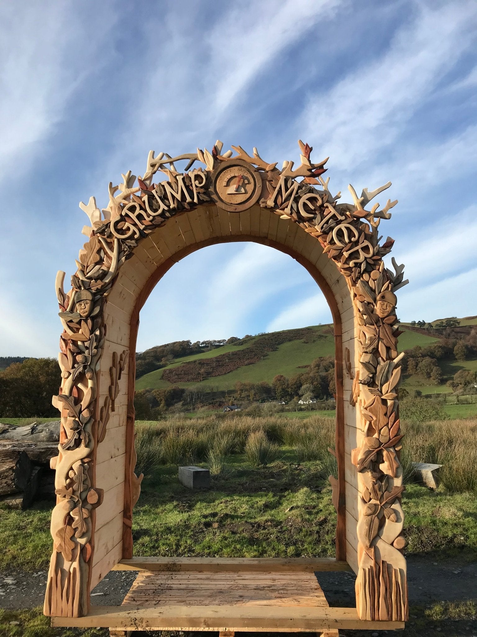 Wooden arch with 'Drump Meter' on a scenic background