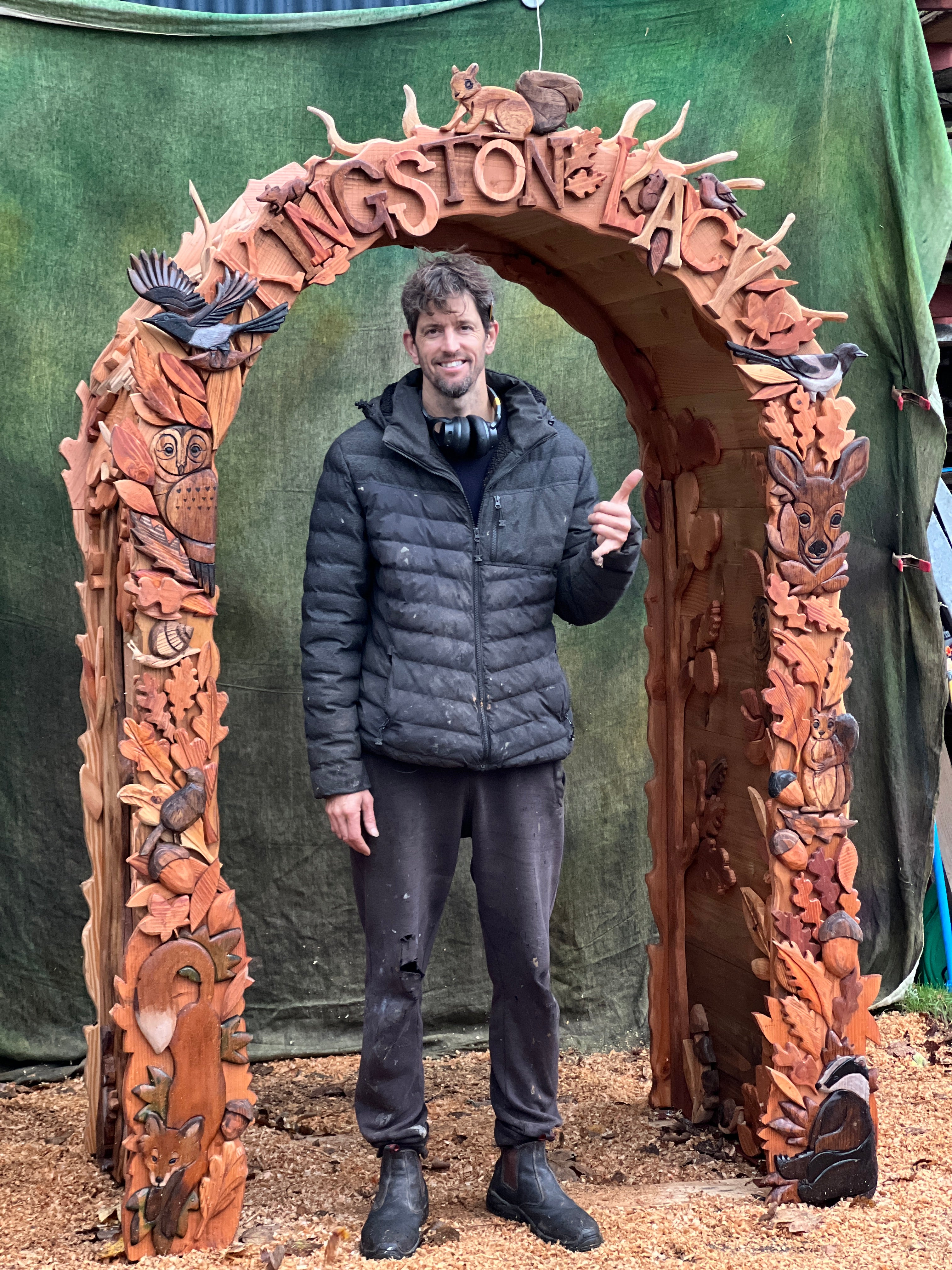 hand carved woodland arch with animals and lettering kingston lacy created by free range designs with me standing beside arch
