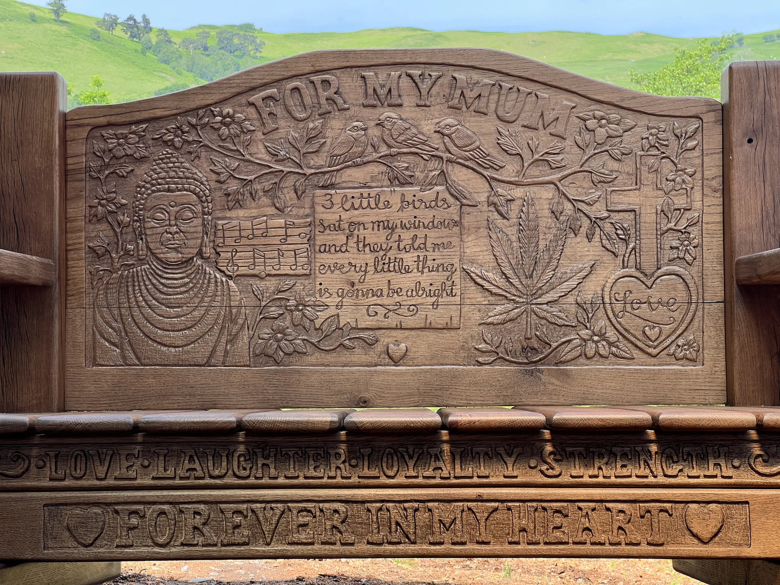Front view of the For My Mum memorial bench in smoked oak with carved scene