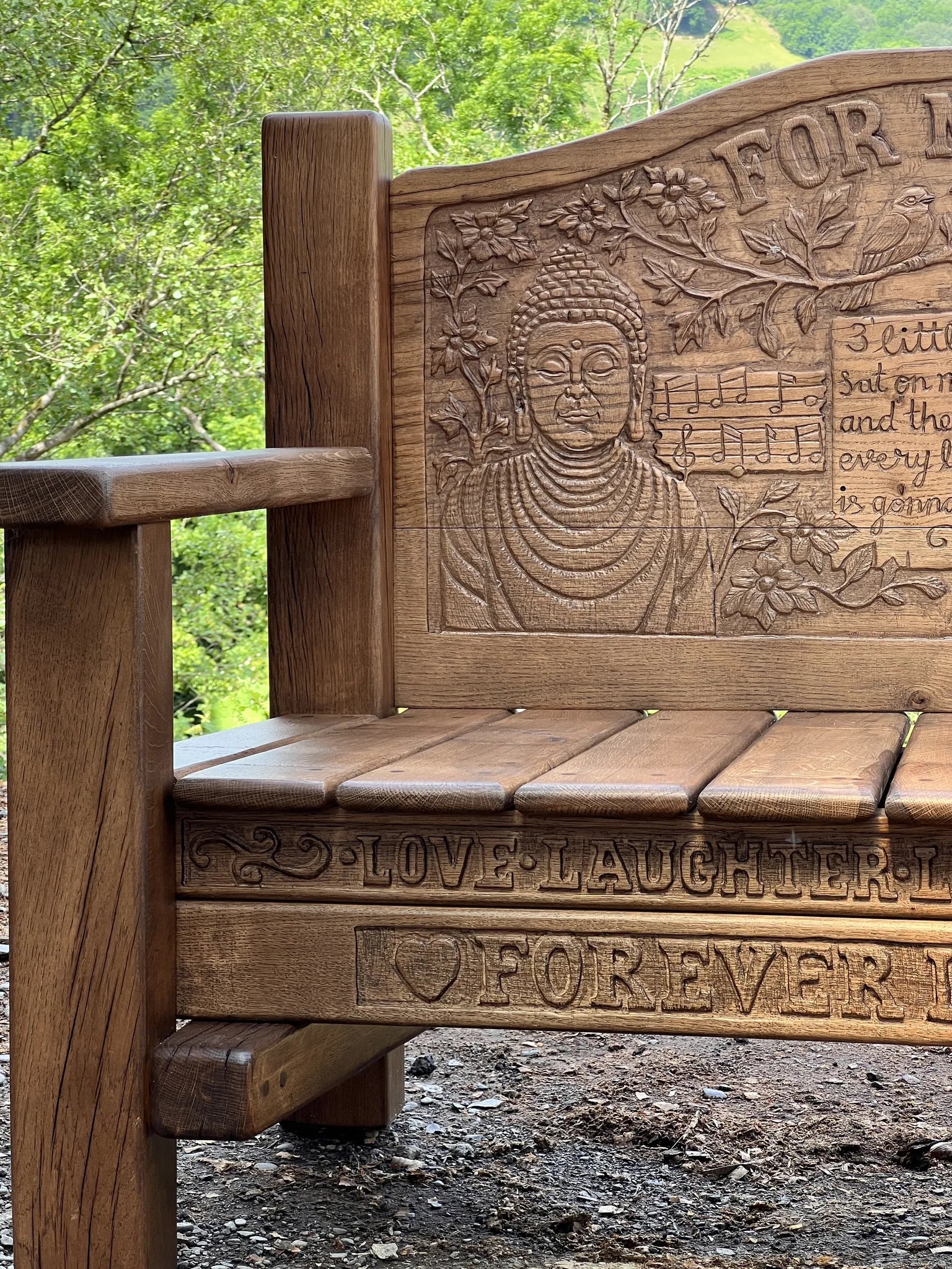 Close-up of the carved leaf and heart detail on the oak memorial bench