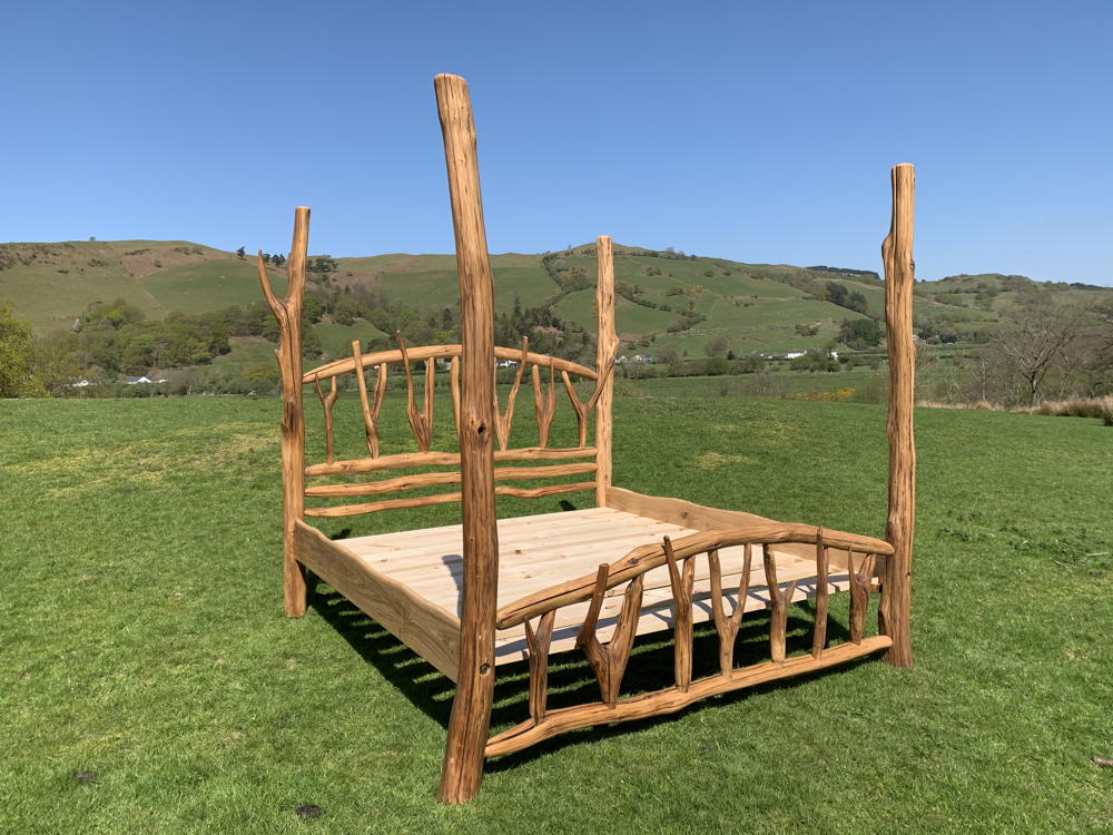 Eco-friendly oak four poster bed with scenic backdrop