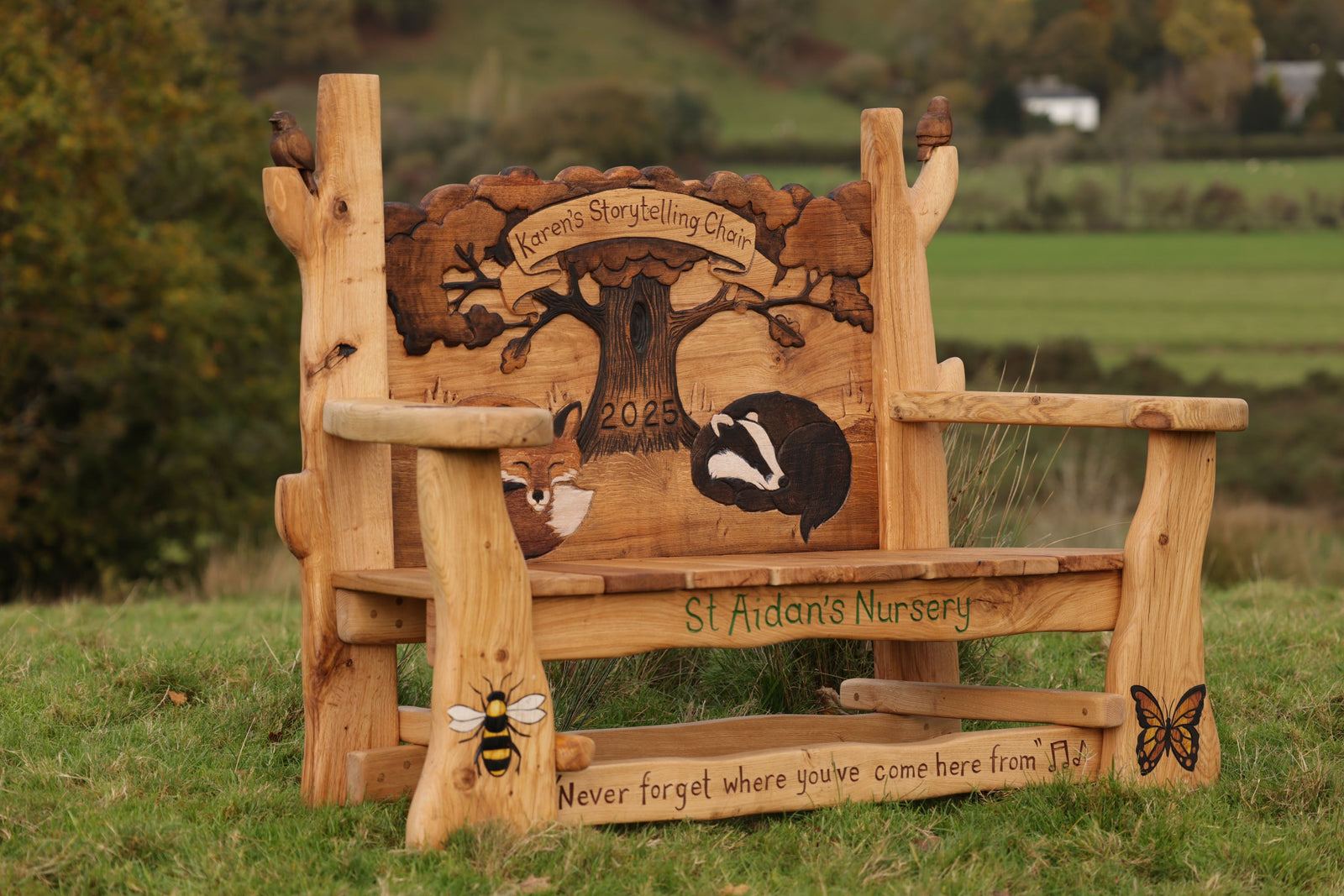 Wooden bench with carvings of animals and text in a natural setting