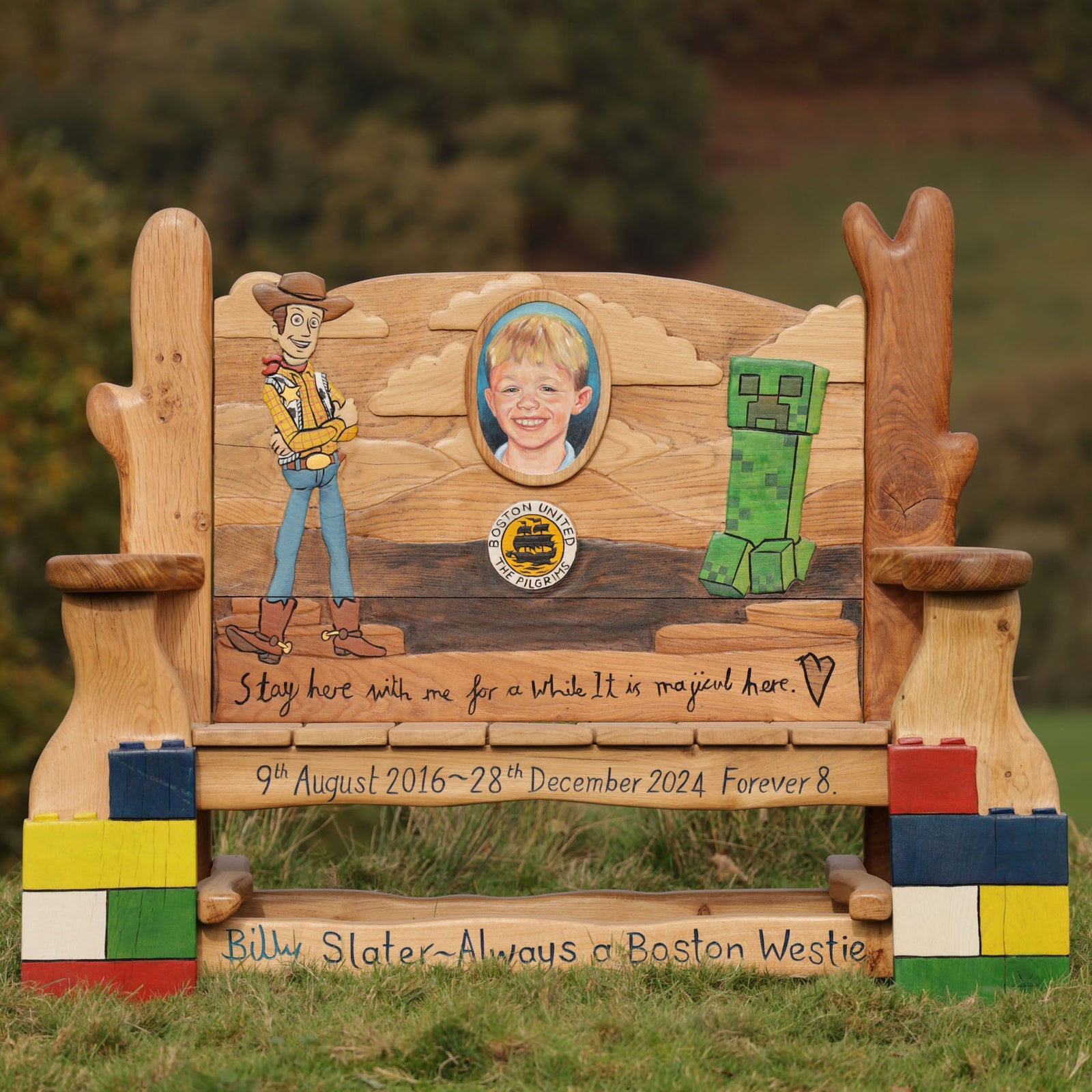 Hand-carved oak memorial bench with cowboy and child portrait carvings — personalised tribute bench handmade in Wales