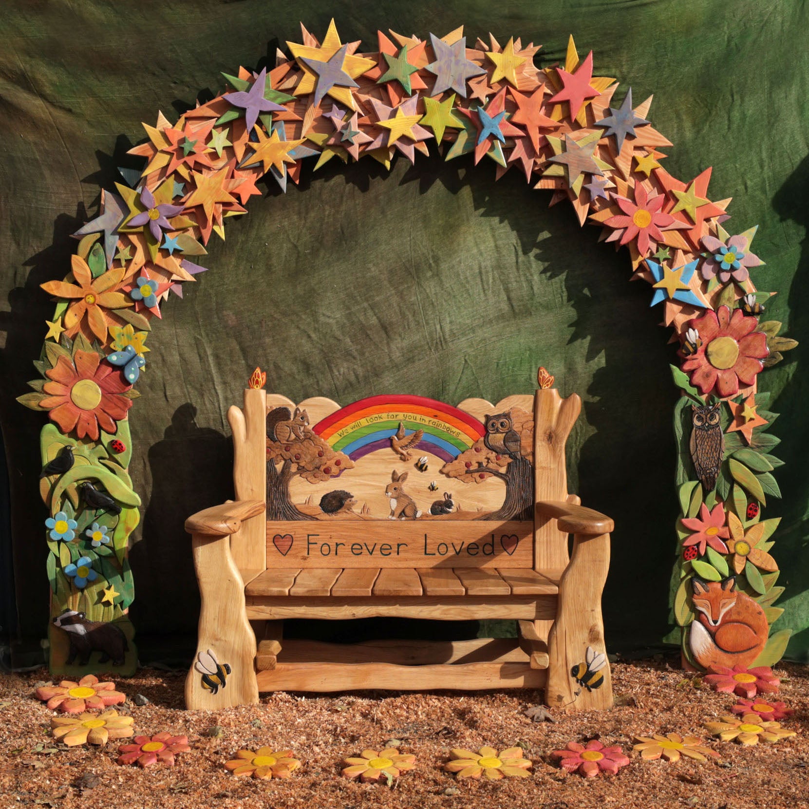 forever loved bench surrounded by colourful carved stars and flowers
