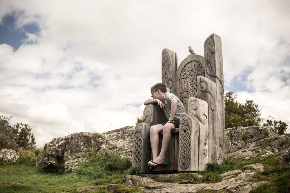 Giant handmade Welsh oak throne beside Harlech Castle — carved statement furniture