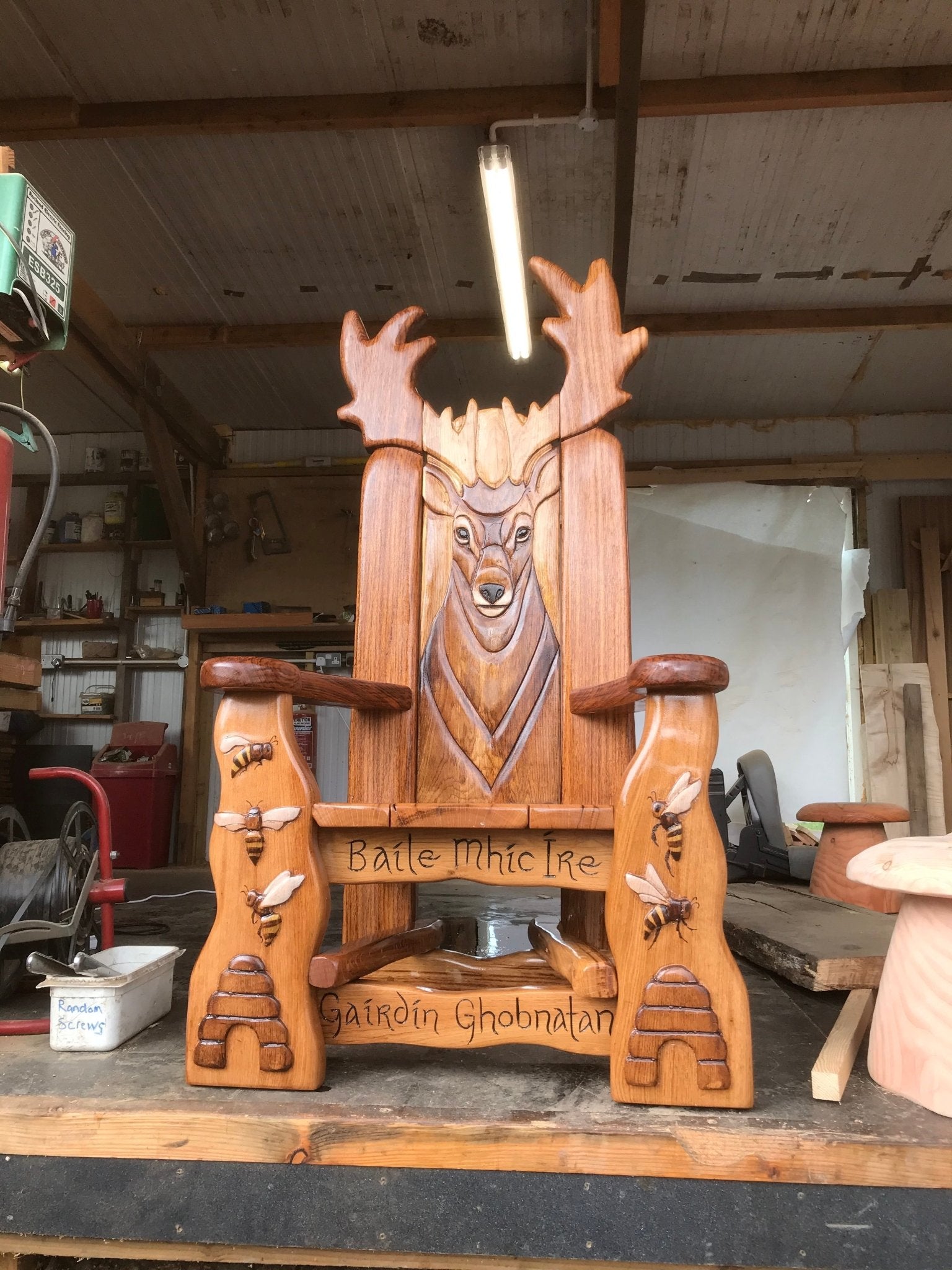 Wooden chair with deer carving in a workshop.