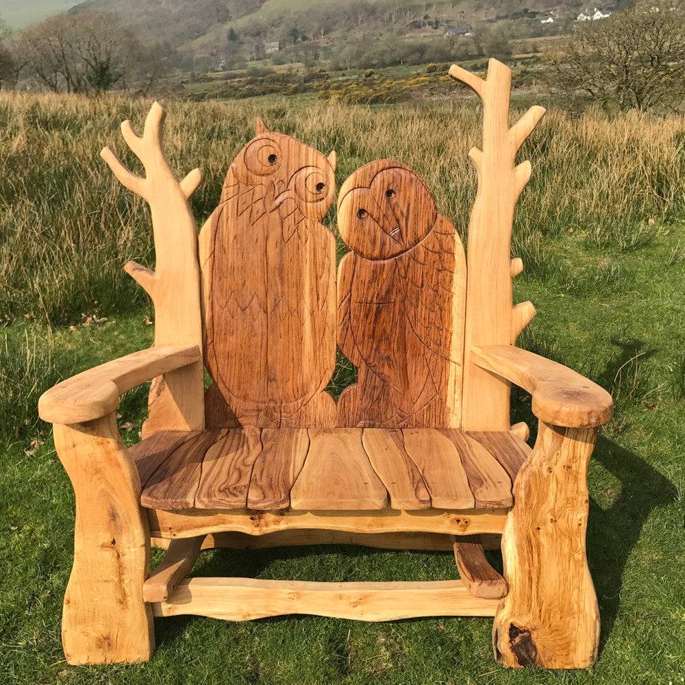 Hand-Carved Wooden Owl Bench made of solid oak, featuring intricate owl designs and rustic charm, ideal for gardens or outdoor seating areas.

