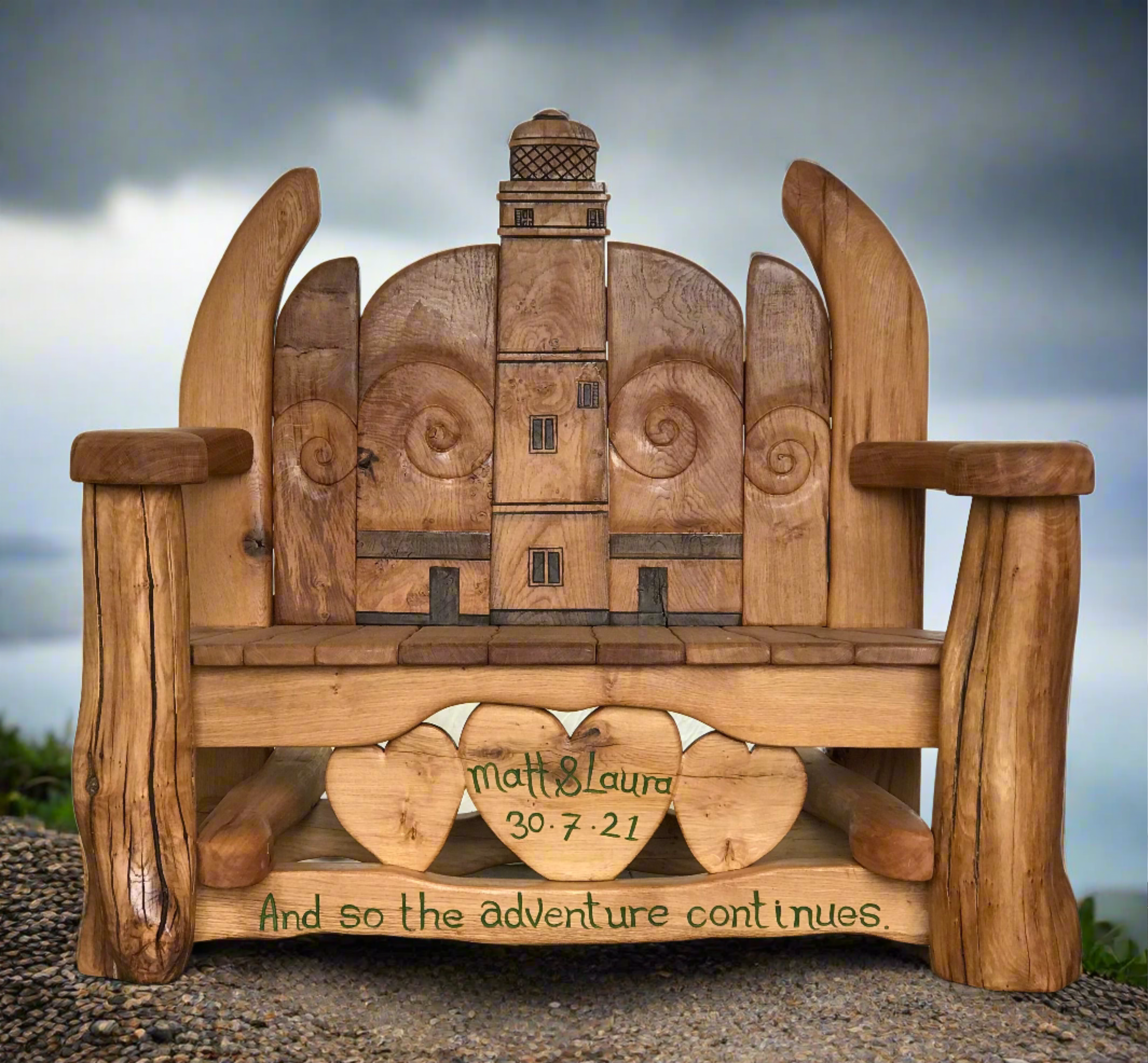 A beautifully handcrafted wooden anniversary bench with a lighthouse design, custom engraving, and heart motifs, ideal for commemorating special occasions in gardens or outdoor spaces.

